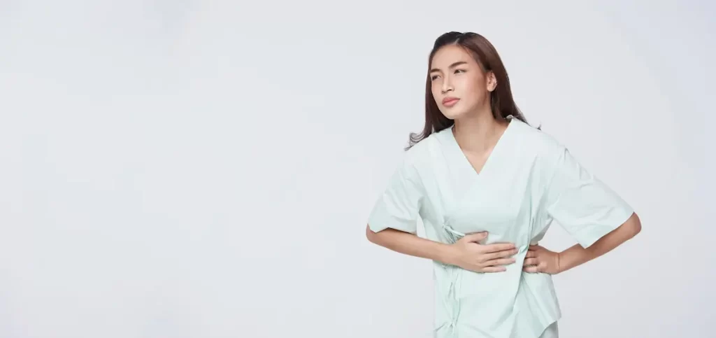 Woman in discomfort, holding abdomen.